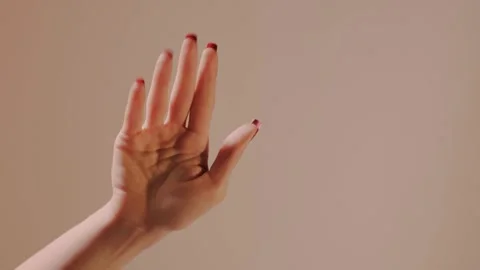 Closeup of elegant hand with glossy red manicure waving farewell slowly toward Stock Footage 319660008