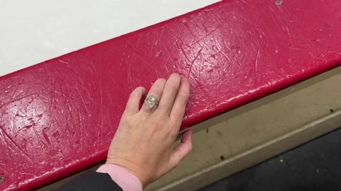 Closeup of elegant hand touching red hockey rink railing on shiny ice Video stock 320015249