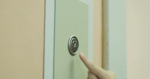 A closeup of an elevator button being repeatedly puched by a childs hand Stock Footage 122429695