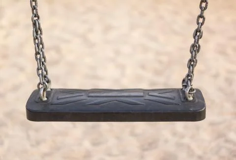 Closeup of empty black swing in a park Stock Photos