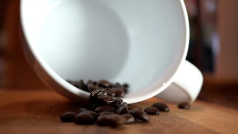 Closeup empty coffee cup with falling coffee beans in slow motion. Stock Footage 104712581
