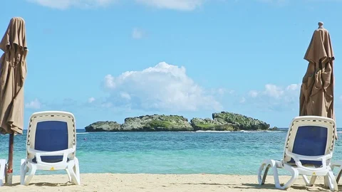 Closeup empty golden sandy seashore with long beach chairs and closed umbrellas Video stock 130033705
