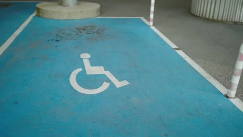 Closeup of an empty handicapped reserved parking space painted blue with a wh Stock Footage 249780095