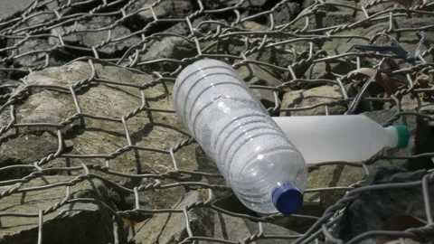 Closeup, empty plastic bottles on local port gabion Stock Footage 137076406