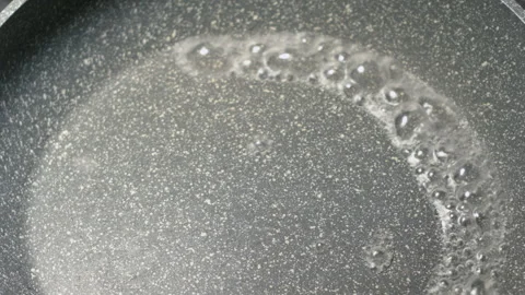 Closeup of an empty red hot griddle on a stove with boiling drops of water. Vídeo Stock 135203044