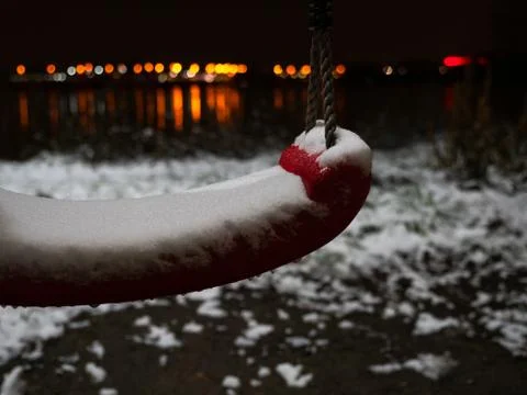 Closeup of empty swing covered by ice at winter night. Stock Photos
