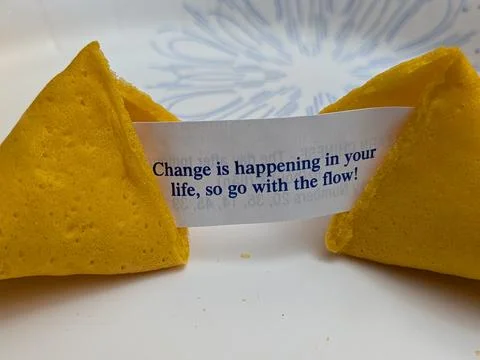 Closeup of an encouraging fortune cookie message about embracing life changes: Stock Photos