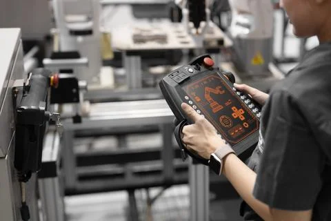 Closeup engineer using industry robot setup operate control by remote contr.. Stock Photos