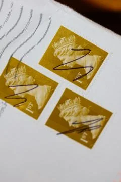 A Closeup of an envelope with three British first class stamps on it Stock Photos