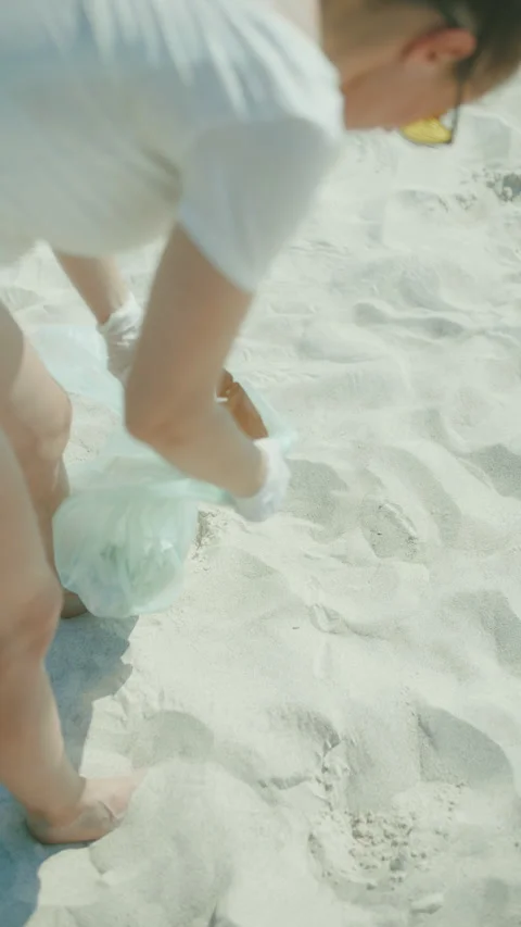 Closeup on environment activist on ocean shore collecting waste Stock Footage 271297588