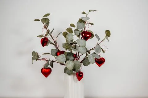 Closeup eucalyptus branches decorated with red heart ornaments for christmas Stock Photos