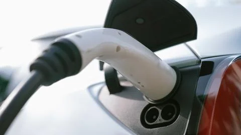 Closeup EV charger handle plugged in or connect to electric car. Synchronos Fotos Stock