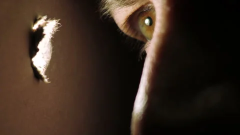 Closeup of Eye Looking into Hole in a Wall Video stock 235947350