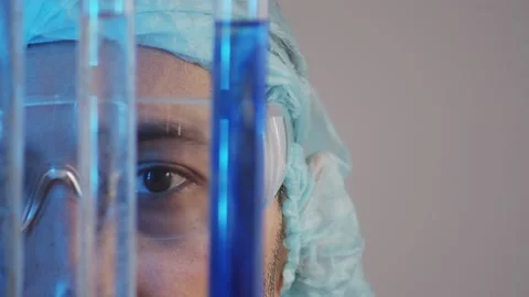 Closeup of eyes observing the diffusion of dissimilar liquids in test tubes in t Stock Footage 233031080