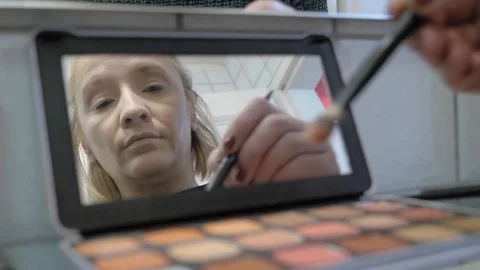 Closeup of eyeshadow palette container as the brush takes the powder. Stock Footage 127655977