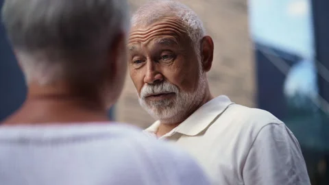 Closeup face of handsome elderly man with white beard happily talking with wife Stock Footage 285744197