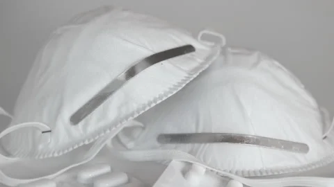 Closeup of face masks and stack of medicine blister packs Stock Footage 130957864