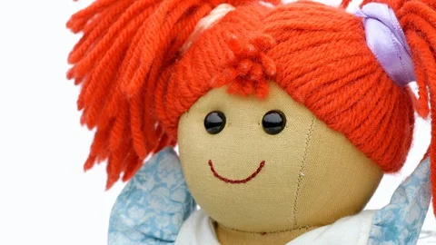 Closeup face rag doll smiling on a white background rotating Stock Footage 128772315