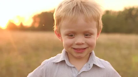 Closeup face of young funny boy in field at sunset Stock Footage