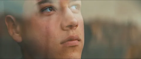 Closeup of the face of a young man staring up hopeful through the window Stock Footage 203586072