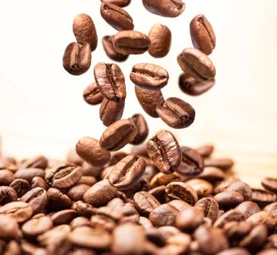 Closeup of falling or flying coffee beans on white Foto stock