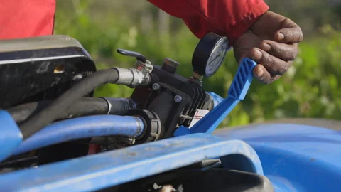Closeup: Farmer on tractor opens valve to start pressurized sprayer Stock Footage 333632420