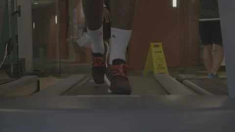 Closeup of Feet Running on a Treadmill Stock Footage 154004499