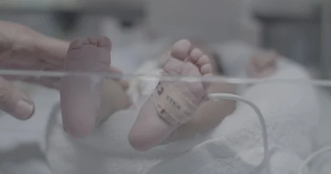Closeup feet of an unknown newborn baby in a bed incubator Stock Footage 127744553