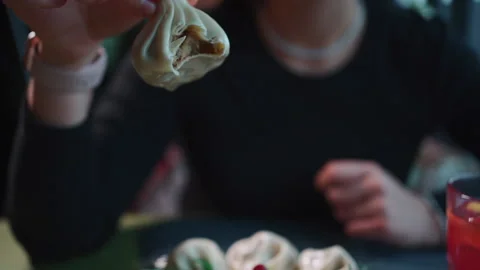 Closeup of female bite and eat georgian khinkali with meat filling in restaurant Stock Footage 200850947