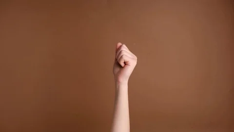 Closeup of female hand making gesture Come closer on the brown background Stock-Footage 123026740