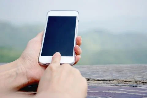 Closeup of female hand using a smart phone. Shallow depth of field Stock Photos