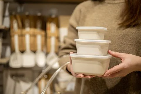 Closeup female hands holding stack of ceramic containers with plastic lid food Stock Photos
