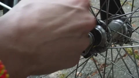 Closeup female hands opening a quick release for a bike wheel. Stock Footage 276423784