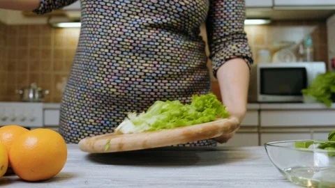 Closeup of female hands preparing vegetable salad in the kitchen. Healthy Foo Stock Footage 121639658