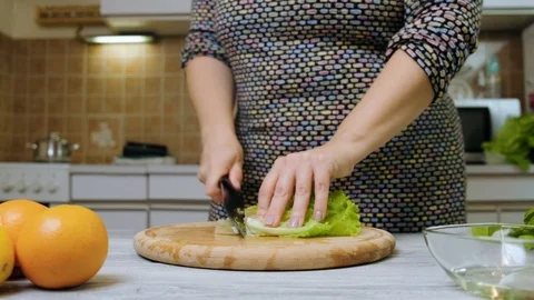 Closeup of female hands preparing vegetable salad in the kitchen. Healthy Foo Stock Footage 121639681
