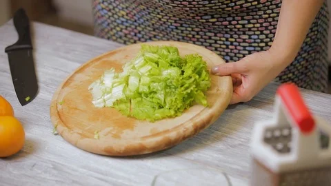 Closeup of female hands preparing vegetable salad in the kitchen. Healthy Foo Stock Footage 121639972