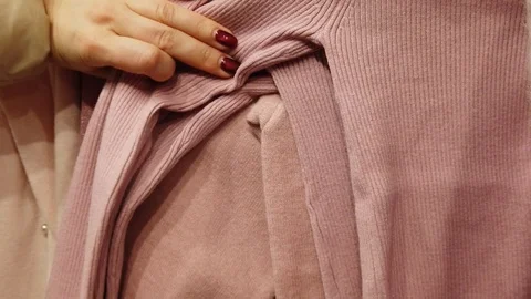 Closeup of female hands sorting through a hanger with clothes. Video stock 122573304