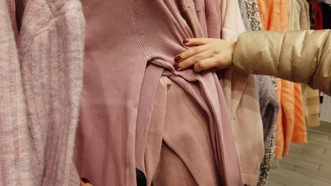 Closeup of female hands sorting through a hanger with clothes. Video stock 124475255