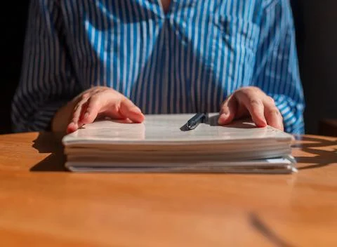Closeup of female hands with stack of documents on wooden table 스톡 사진