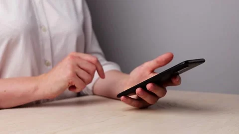 Closeup female relaxes in home using smartphone scrolling on text message or Stock Footage 336249734