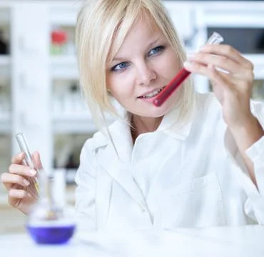 Closeup of a female researcher holding up a test tube and a reto Stock Photos