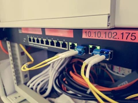 Closeup of fiber optic cable plugged into switch Stock Photos