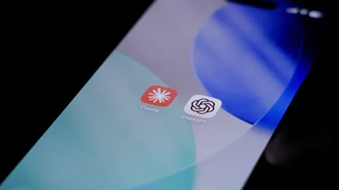 Closeup of finger deleting Claude mobile app beside ChatGPT icon on smartphone Stock Footage 334059961