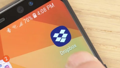 Closeup on a Finger Opening Dropbox app Icon on a Smartphone Stock Footage 107229833