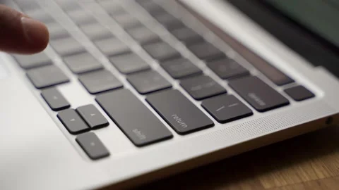 Closeup of finger pressing enter key on modern laptop keyboard. Man pushes enter Stock Footage 156619346