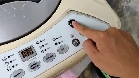 Closeup of Finger Pressing Start Button on Washing Machine Control Panel Video stock 304255366