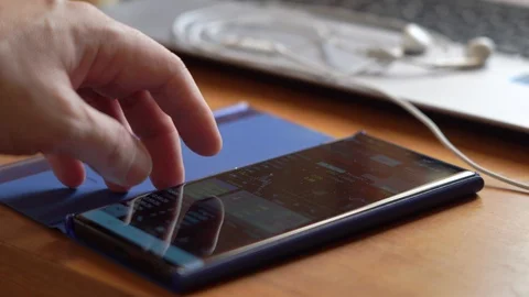 Closeup finger scrolling touching smartphone screen, Trading or investing online Stock Footage 128670677