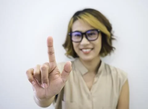 Closeup finger touch on virtual touch screen by happy smile Asian woman short Stock Photos