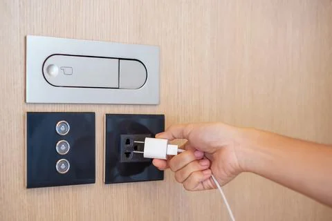 Closeup finger unplugging or plugging of electricity device at home. Energy.. Stock Photos