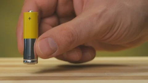 Closeup of the fingers of a man put on the table six AA batteries Stock Footage 123631633